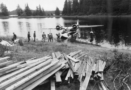 Coastal-Ellis plane unloading lumber for a Forest Service cabin