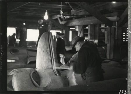Men working on totem poles in the Saxman CCC carving shed, 1940